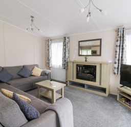 A living room with a sofa and television at Beechwood Lodge