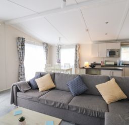A living room with a sofa and dining area at Beechwood Lodge