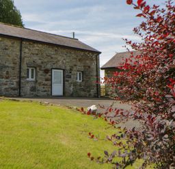 A stone building with windows and a door at Shearers in Llandysul