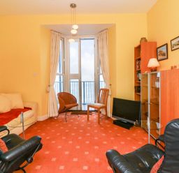 A living room with a sofa and two chairs at Val's Seaview in Ilfracombe
