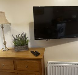 A living room with a television and lamp on a chest of drawers at The Rocks in Newry
