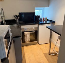 A kitchen with stove, oven, sink, and refrigerator at Studio Apartment at High Dyke Farm in Cockermouth
