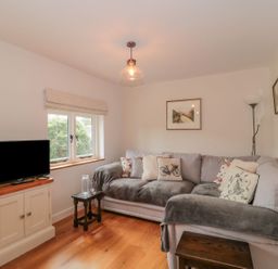 A living room with a sofa and television at Greenham Rise in Norton-Sub-Hamdon
