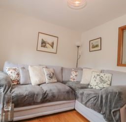 A living room with a sofa and paintings at Greenham Rise in Norton-Sub-Hamdon