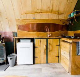 A kitchen with wooden cabinets and appliances at Glamping pod-Luxury Glamping Retreat in Battle