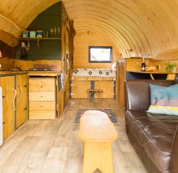 A living room with a kitchen area and a sofa at Glamping pod-Luxury Glamping Retreat in Battle
