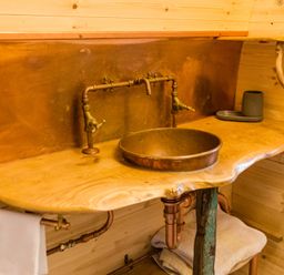 A bathroom with a wooden sink and faucet at Glamping pod-Luxury Glamping Retreat in Battle