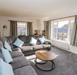A living room with a sofa and coffee table at Tymelyn in Aberystwyth