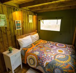 A bedroom with a bed and bedside table at Badger - Luxury Glamping Retreat in Battle