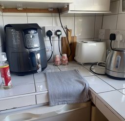 A kitchen with an air fryer, toaster, kettle, and cleaning spray at Tylands in Camelford