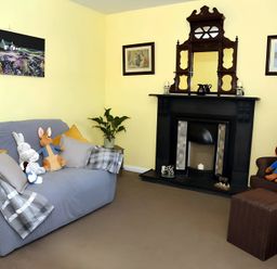 A living room with a sofa and a fireplace at The Farmhouse in Omagh