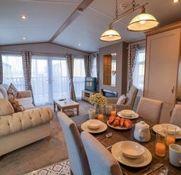 A living room with a dining table and sofa at Paws By The Sea in Norwich