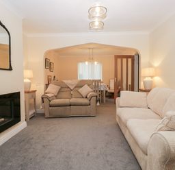 A living room with sofas and a fireplace at Mables in Wigton