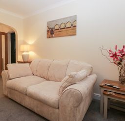 A living room with a sofa and lamp at Mables in Wigton