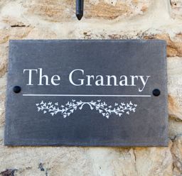 A sign that reads The Granary on a stone wall