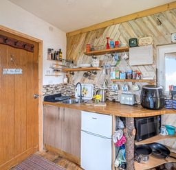 A kitchen with a sink and various kitchen appliances at The Retreat Cabin in Llanelli