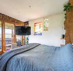 A bedroom with a bed and television at The Retreat Cabin in Llanelli