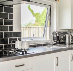 A kitchen with a window and appliances at The lodge at Plumstone View Letterston