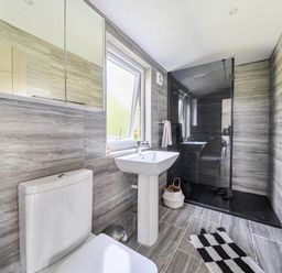A bathroom with a toilet, sink, and shower at The lodge at Plumstone View in Letterston