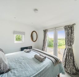 A bedroom with a bed and a window at The lodge at Plumstone View Letterston