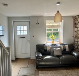 A living room with a sofa and a window at Penderyn Cottage Aberdare