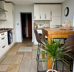 A kitchen with cabinets and a table at Penderyn Cottage Aberdare