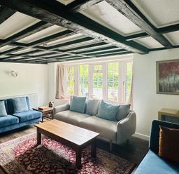 A living room with sofas and a wooden table at The Bark House in Tiverton