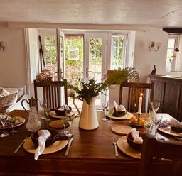 A dining room with a table set for a meal at The Bark House in Tiverton