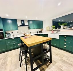 A kitchen with cabinets and an island at The Bark House in Tiverton