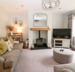 A living room with a fireplace and television at East View in Cheltenham