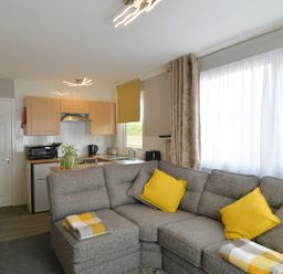 A living room with a sofa and kitchen area at 228b Eighth Avenue Bridlington