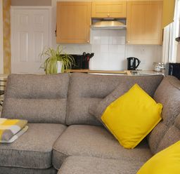 A living room with a sofa and kitchen area at 228b Eighth Avenue in Bridlington
