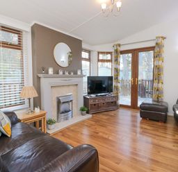 A living room with a sofa and television at 6 Waterside in Windermere