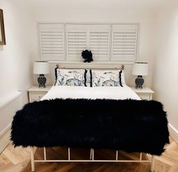 A bedroom with a bed, nightstands and lamps at 6 Tegafan in Abergele