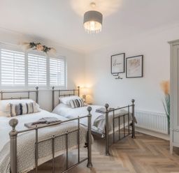 A bedroom with two beds and a wardrobe at 6 Tegafan in Abergele