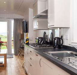 A kitchen with a sink and cooker at Nethermill Lodges in Port Glasgow