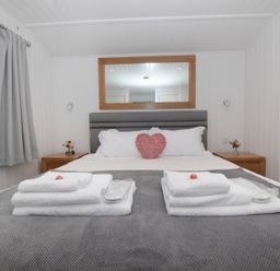 A bedroom with a bed and bedside table at Nethermill Lodges in Port Glasgow
