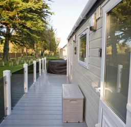 A deck with storage box and railing at Orchid 9 Christchurch