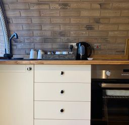 A kitchen with sink kettle and oven at Cosy Escape Sheerness