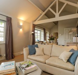 A living room with a sofa and a dining table at Foxhill Farm Barn in Cheltenham