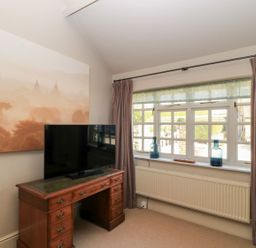 A living room with a television and desk at Foxhill Farm Barn Cheltenham