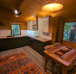 A kitchen with cabinets and a dining table at Pineshadow Lodge in Louth