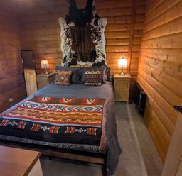 A bedroom with a bed, bedside table and lamp at Pineshadow Lodge in Louth