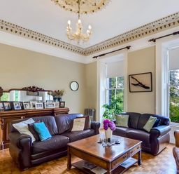 A living room with seating, a coffee table, and decorative elements at Fountain Hill House in Londonderry