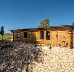 An outdoor area with a wooden cabin and a picnic table at Cotswold Nights Ashton Under Hill