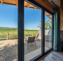 A living room with glass doors leading to a garden at Cotswold Nights in Ashton Under Hill