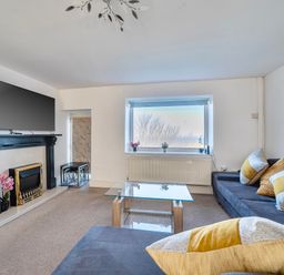 A living room with a sofa and television at Sea view cottage Penmaenmawr