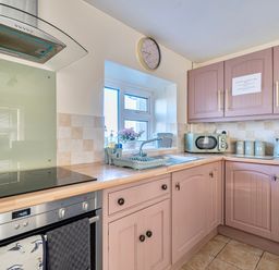 A kitchen with sink and appliances at Sea view cottage in Penmaenmawr