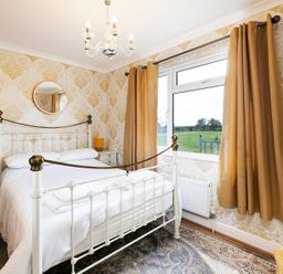 A bedroom with a bed and nightstand at Hedgehog Lodge in York