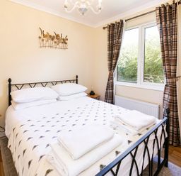 A bedroom with a bed and window at Hedgehog Lodge in York
